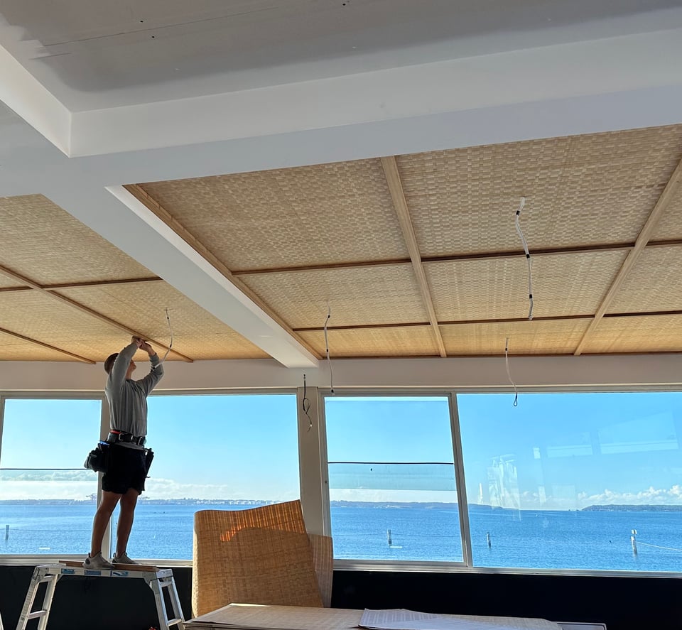 Installer fixing rattan ceiling panels in a Manly interior