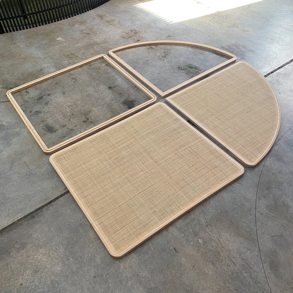 Curved and square rattan panels in bamboo frames laid out in the factory